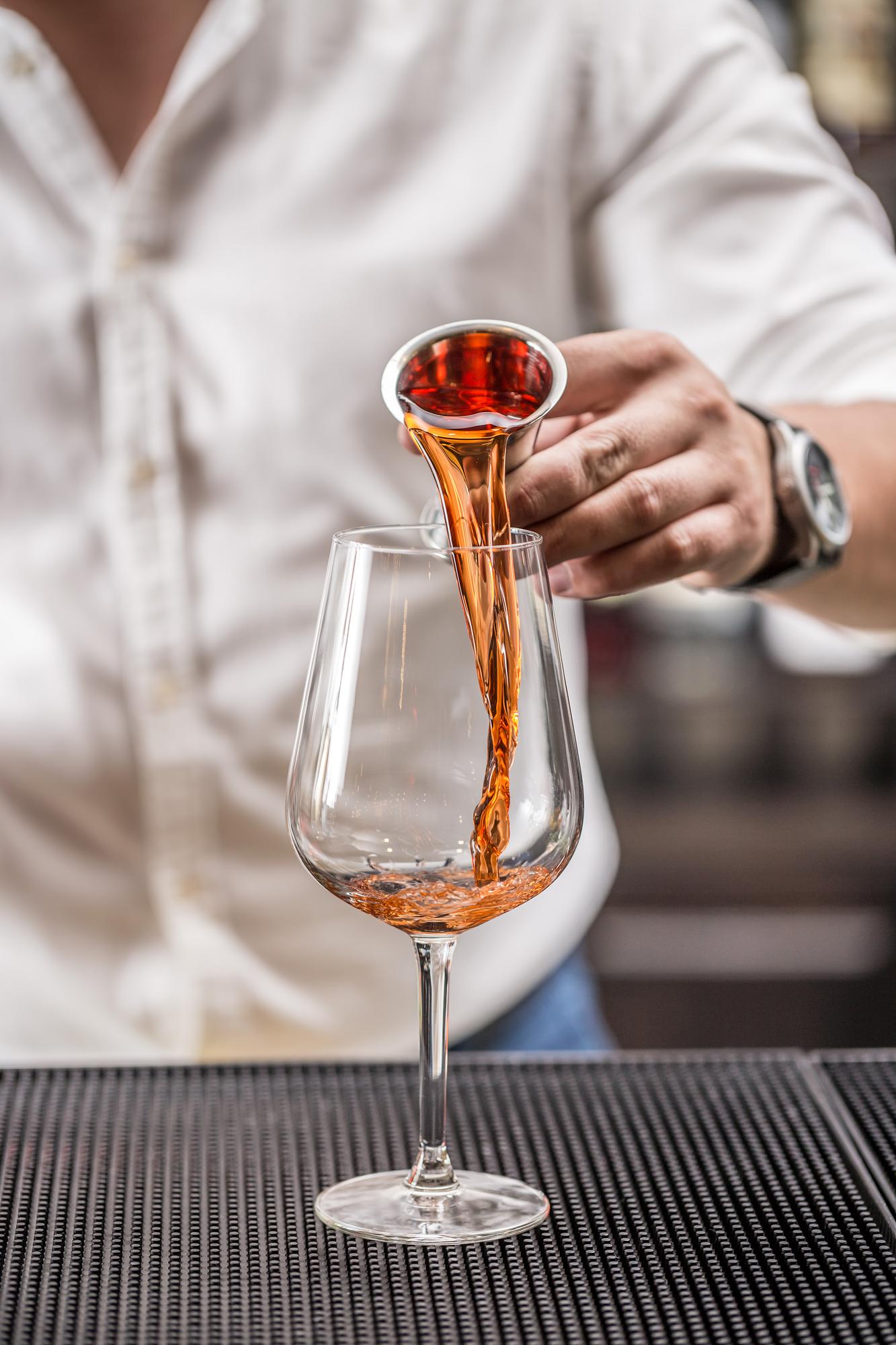 Sommelier pouring amber wine
